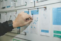 Hand pinning paper onto a board chain